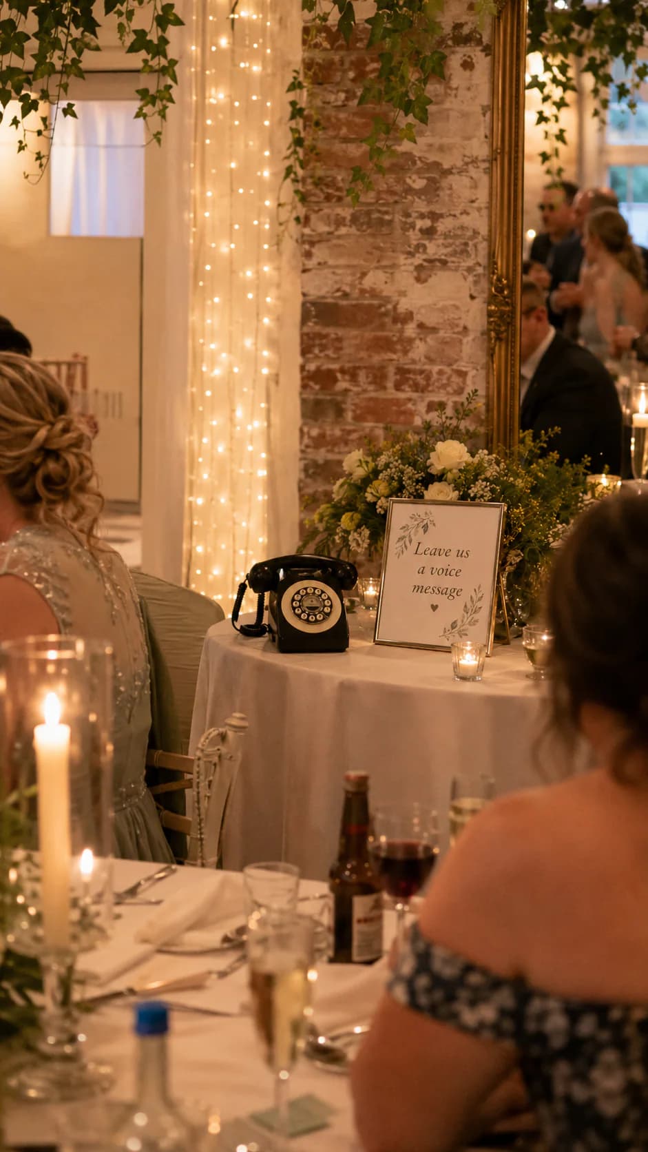 Black audio guest book telephone beside a voice-message sign during a wedding reception